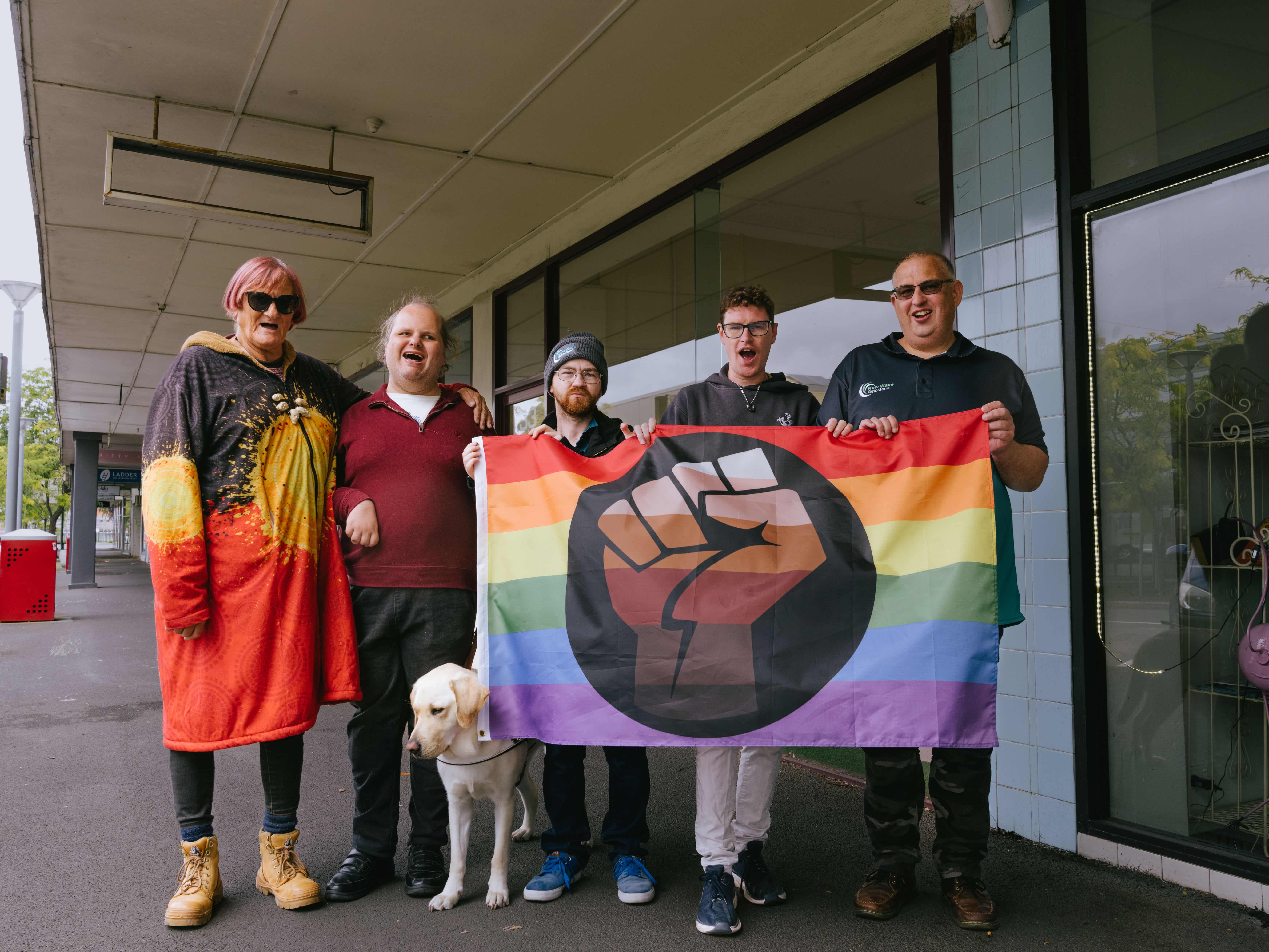 5 members of New Wave Rainbow Pride holding Pride flag